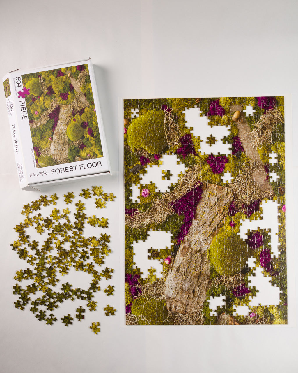 504 piece jigsaw puzzle titled 'Forest Floor' with a forest and moss design being assembled