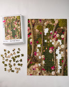 504 piece jigsaw puzzle of green moss wall with flowers and wood in nature being assembled
