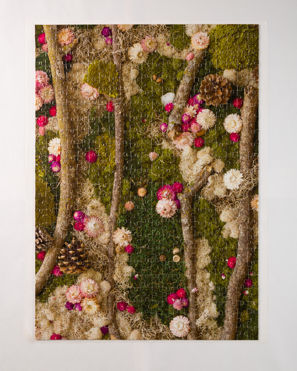 Completed 504 piece jigsaw puzzle of green moss wall with flowers and wood in nature