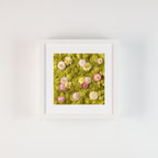 Pastel flowers on a green moss wall fine art print in frame on white wall