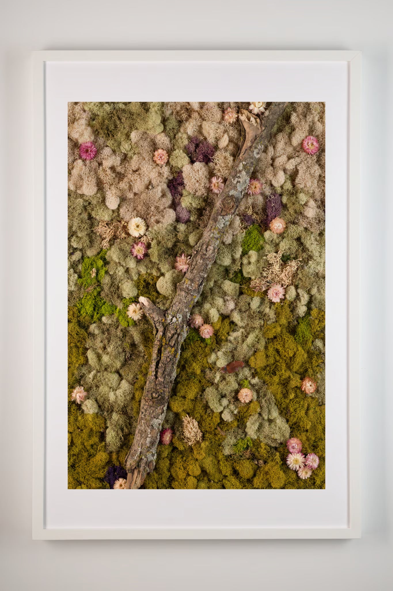 Nude and green moss wall with wooden log and blush flowers fine art print shown in white frame
